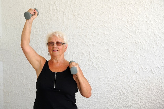 Mulher idosa fazendo exercícios com halteres