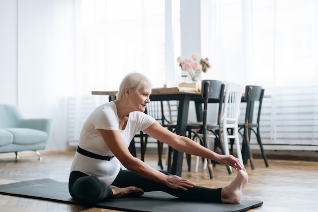 Mulher idosa fazendo exercícios de fitness em seu conceito de sala de estar de um estilo de vida saudável