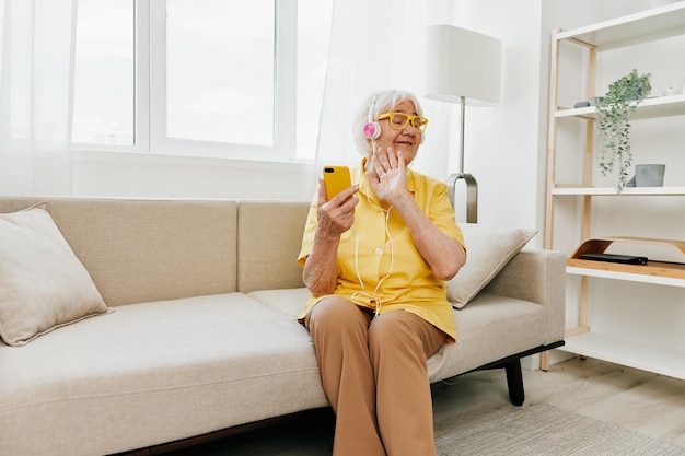 Mulher idosa feliz olhando para a tecnologia de sorriso de chamada de vídeo para comunicação comunicação on-line de estilo de vida interior moderno e brilhante