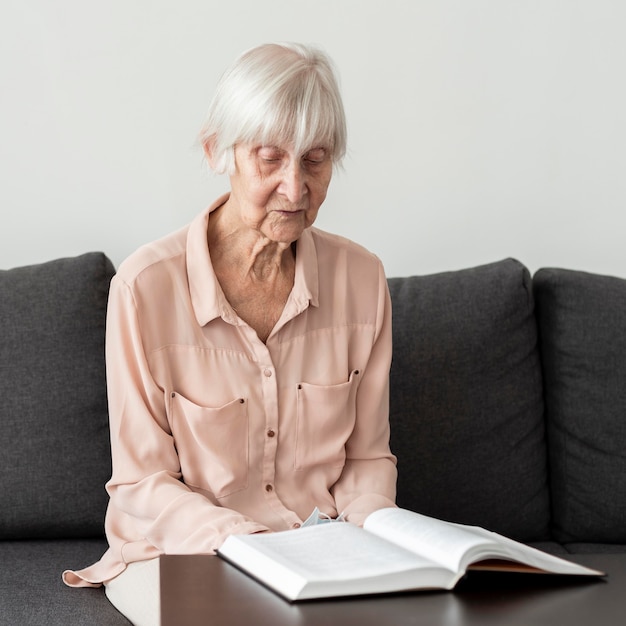 Foto mulher idosa lendo um livro na casa de repouso