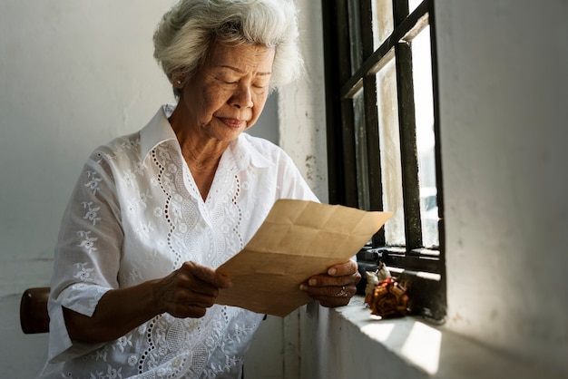 Mulher idosa, lendo uma carta