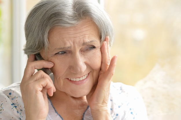 Mulher idosa ligando em casa