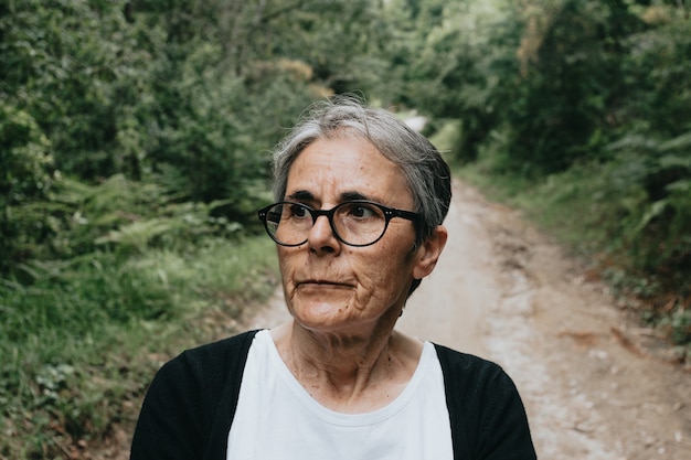 Mulher idosa madura, séria e preocupada, pensativa, triste, olhando para longe, pensando em solidão, envelhecimento e depressão