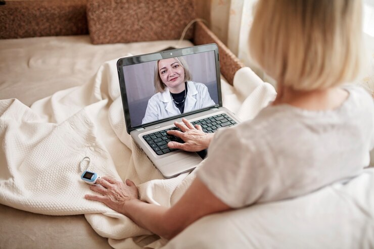Foto mulher idosa na cama, olhando para a tela do laptop e consultando um médico online em casa, serviços de telessaúde durante o bloqueio, videochamada distante, aplicativo de saúde de tecnologia moderna