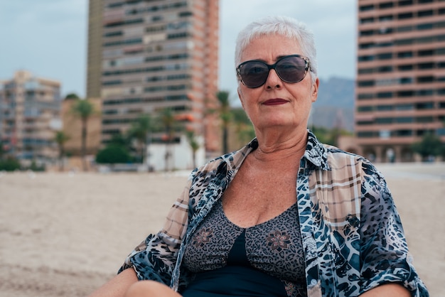 Mulher idosa na praia de óculos