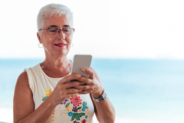 Mulher idosa no telefone celular em casa