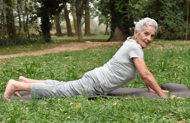 Mulher idosa, prática, ioga, ao ar livre