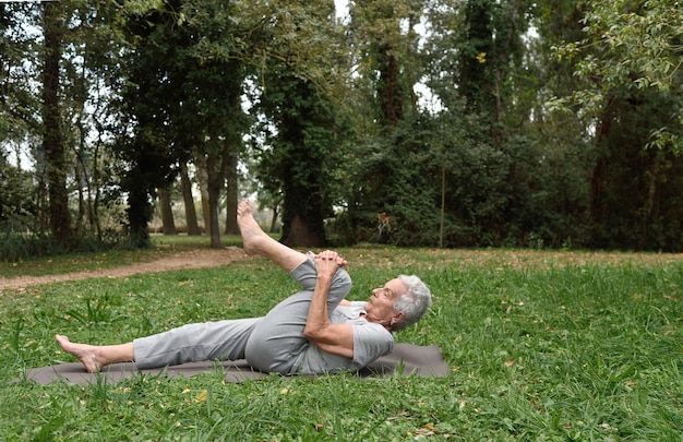 mulher idosa praticando ioga ao ar livre