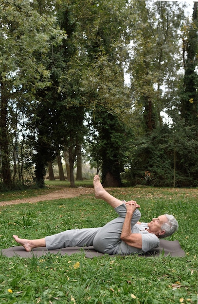 mulher idosa praticando ioga ao ar livre