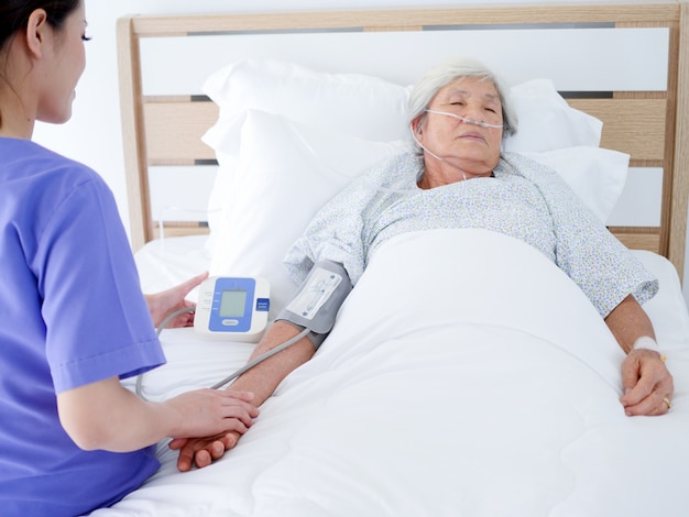 Mulher idosa que encontra-se na cama de hospital.