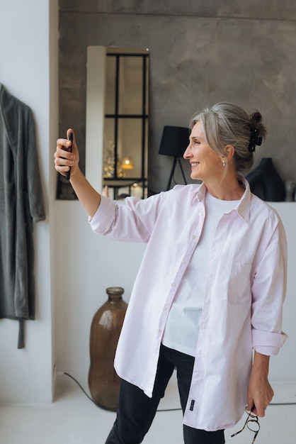 Mulher idosa sonhadora animada confiante alegre tomando selfie