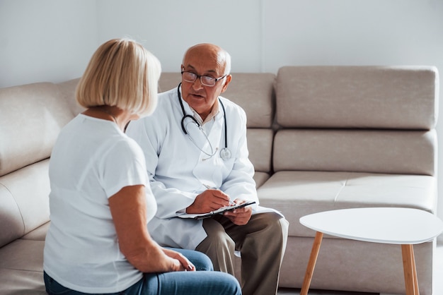 Mulher idosa tem consulta na clínica pelo médico.