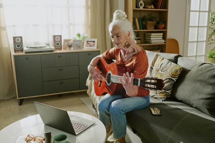 Foto mulher idosa tocando guitarra na acolhedora sala de estar