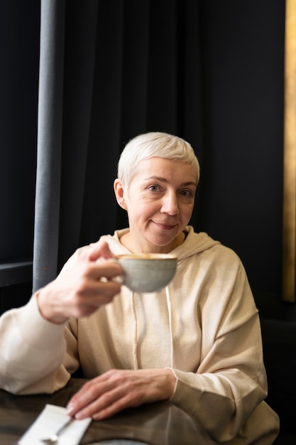 Mulher idosa tomando café em um café