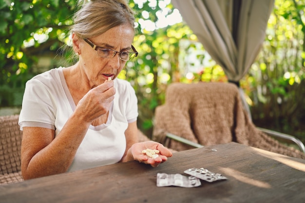 Mulher idosa tomando remédio