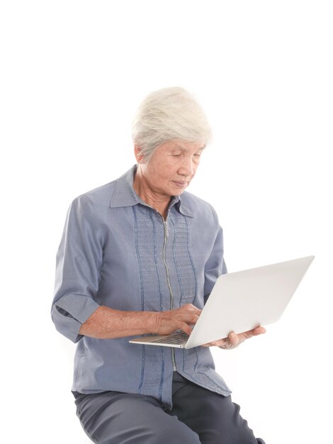 Foto mulher idosa usando laptop contra fundo branco