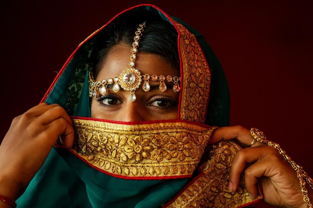 Mulher iluminando diyas com piercing no nariz nuth nath e a teca dourada com sari de moda tradicional