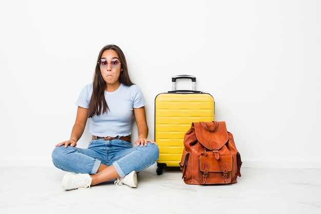 Mulher indiana de raça mista jovem pronta para ir viajar ombros ombros e abrir os olhos confusos.