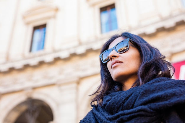 Mulher indiana nova que olha acima na cidade