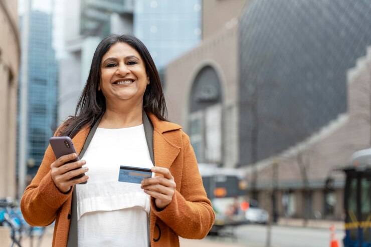 Foto mulher indiana sorridente segurando cartão de crédito recebe pagamento na rua