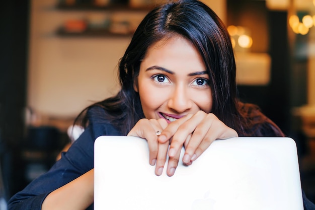 Mulher indiana sorrindo e olhando para o laptop