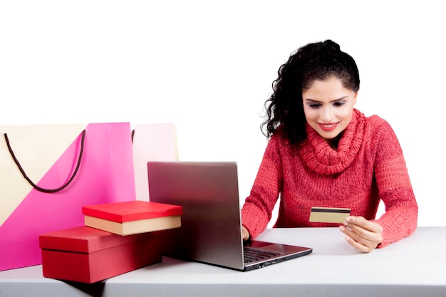 Foto mulher indiana usando um cartão de crédito e um laptop