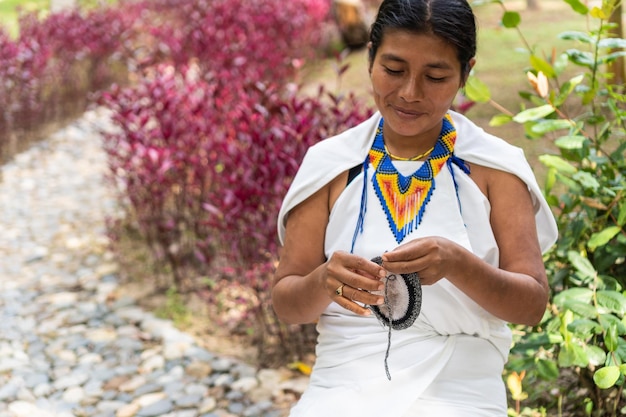 Foto mulher indígena fazendo tecelagem tradicional