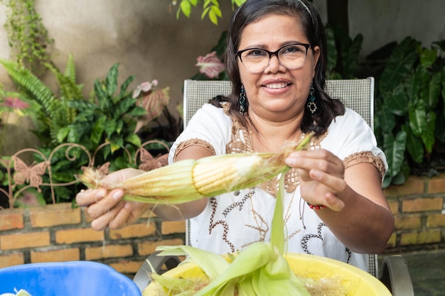 Mulher indígena mexicana descascando milho para criar massa para tortillas, uma comida típica mexicana