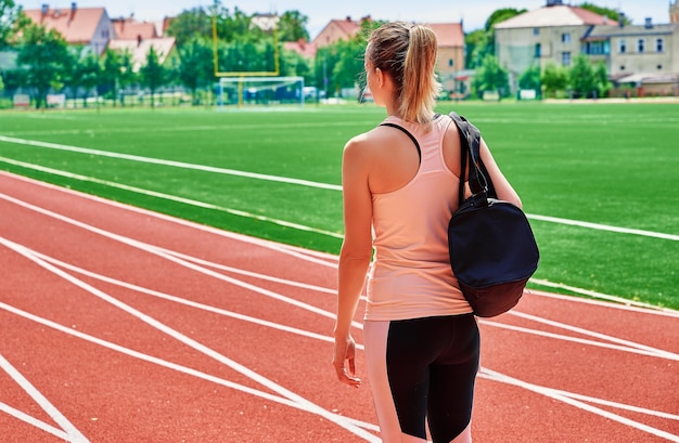 Mulher indo em treinamento físico com bolsa esportiva