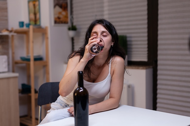 Mulher infeliz com vício em álcool bebendo vinho sozinha