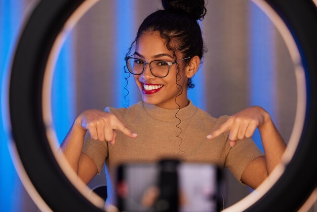 Foto mulher influenciadora anel de luz e retrato com sorriso apontando e beleza na transmissão ao vivo ou vídeo na web revisão de garota ou empreendedora online com maquiagem de felicidade ou falando nas mídias sociais