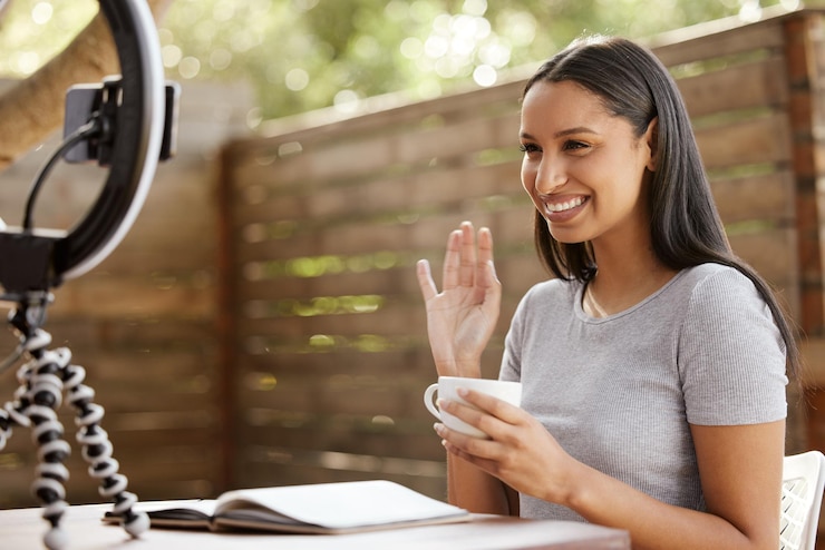 Foto mulher influenciadora e café ao ar livre para vlog onda e falar on-line em diário de gratidão para o autocuidado pessoa feminina café e comunicação com o público por streaming ao vivo expresso e conselhos