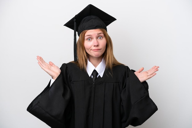 Mulher inglesa jovem graduada na universidade isolada no fundo branco com dúvidas ao levantar as mãos