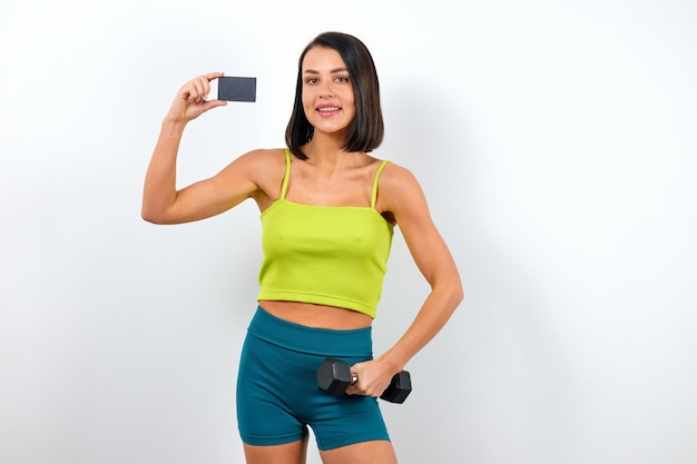 Foto mulher instrutora de fitness segurando cartão plástico com maquete