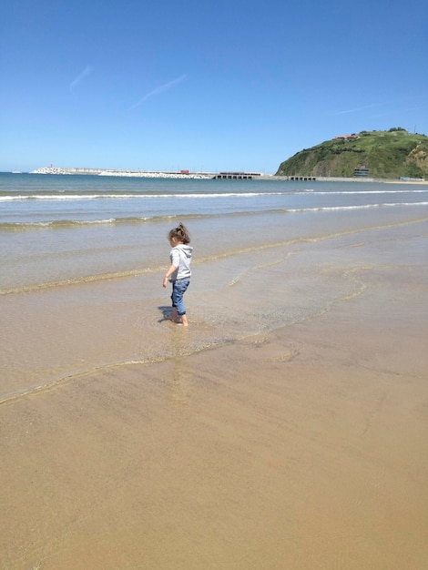 Mulher irreconhecível caminhando na praia