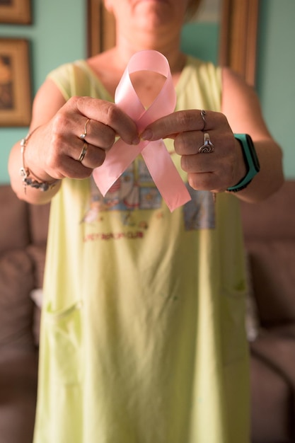 Mulher irreconhecível segurando fita rosa de conscientização de câncer de mama