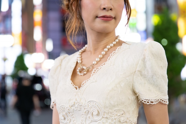 Mulher japonesa com colar glamouroso nas ruas de Tóquio, Japão