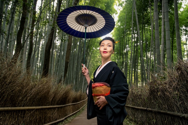 Mulher japonesa com quimono na floresta de bambu de Arashiyama