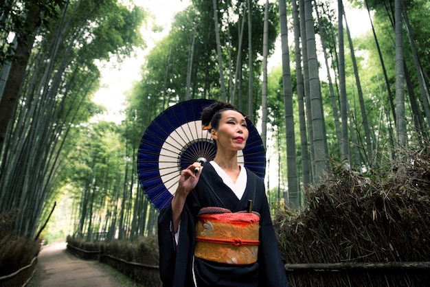 Mulher japonesa com quimono na floresta de bambu de Arashiyama