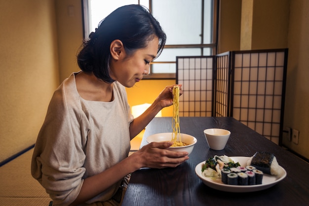 Mulher japonesa comendo em um apartamento tradicional