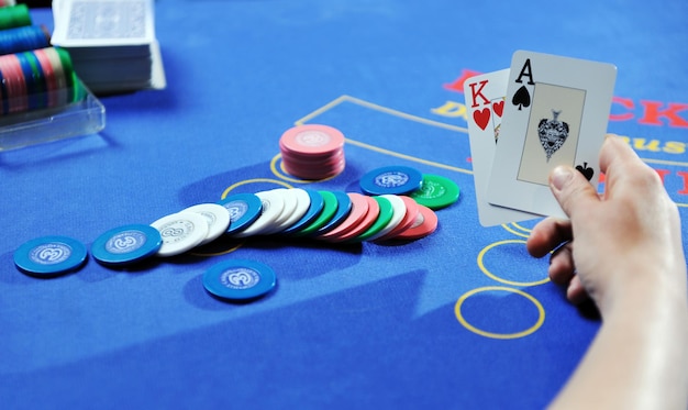 mulher joga jogo de cartas black jack no cassino na mesa azul