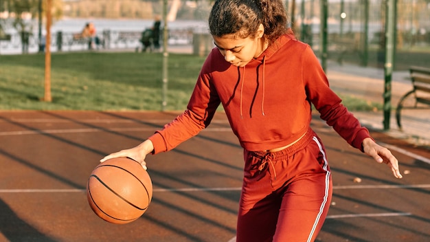 Foto mulher jogando basquete no campo