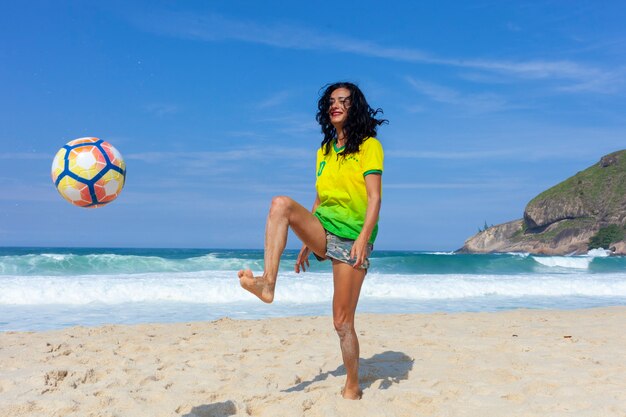 Mulher jogando bola na praia, Rio de Janeiro.