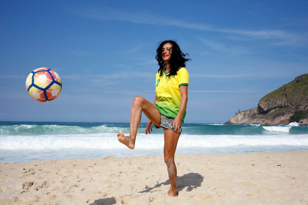 Mulher jogando bola na praia