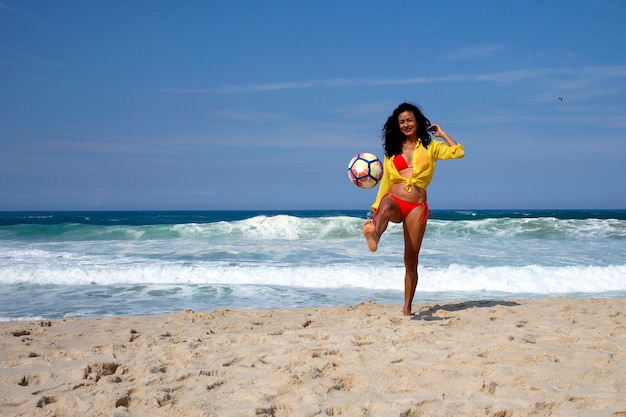 Mulher jogando bola na praia