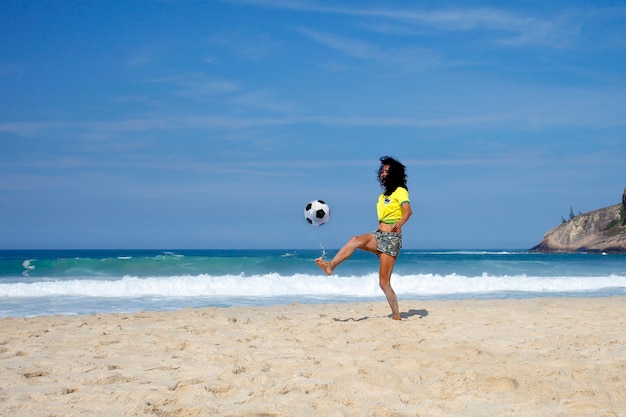 Mulher jogando bola na praia