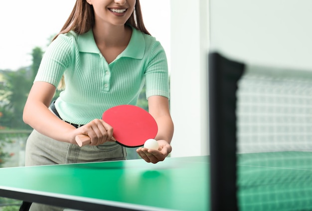 Mulher jogando pingue-pongue dentro de casa visão aproximada Espaço para texto