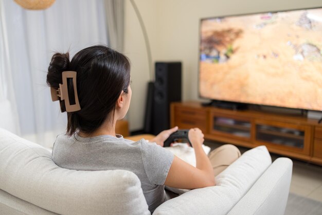 Mulher jogando videogame em casa