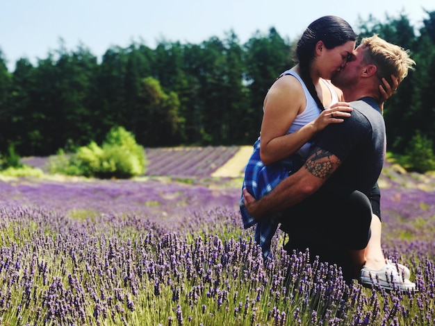 Foto mulher jovem a beijar-se enquanto está de pé na quinta