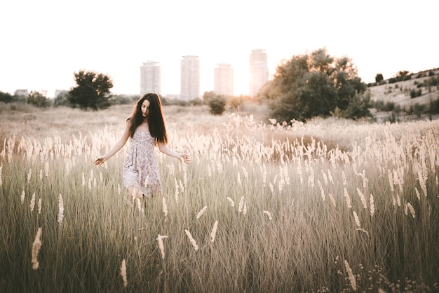 Mulher jovem a caminhar entre as plantas no campo